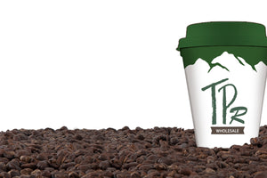 This image shows a coffee cup with TPR Wholesale standing in a bed of roasted coffee beans.  The link is for TPR Wholesale.