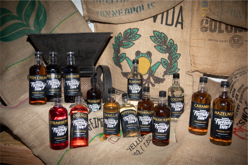 Picture containing Barista22 syrups with coffee bags and a coffee fruit processing equipment